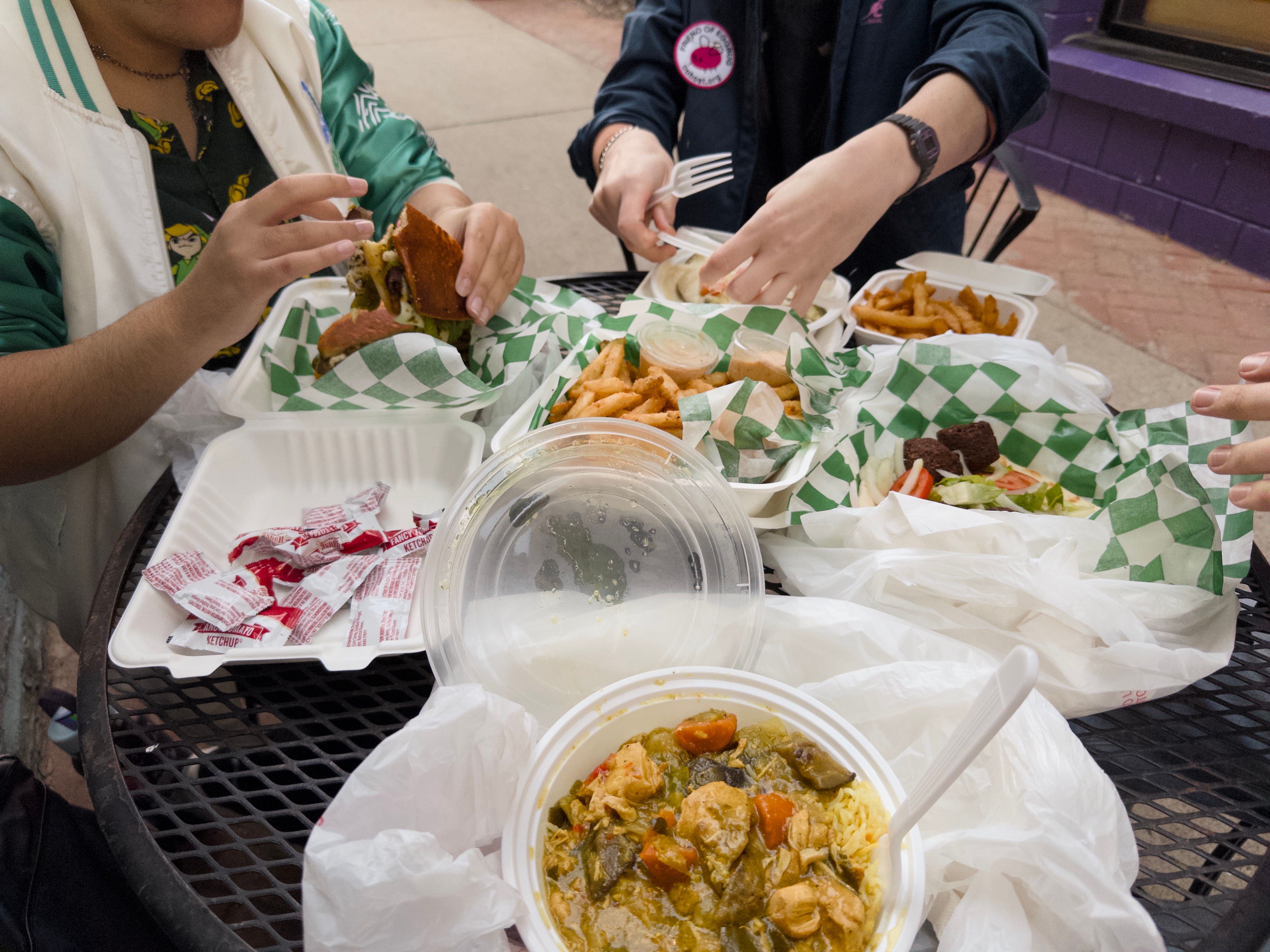 The training home group eating food together. The focus of the image is on the food. We’re eating some curry, falafel, and fries.