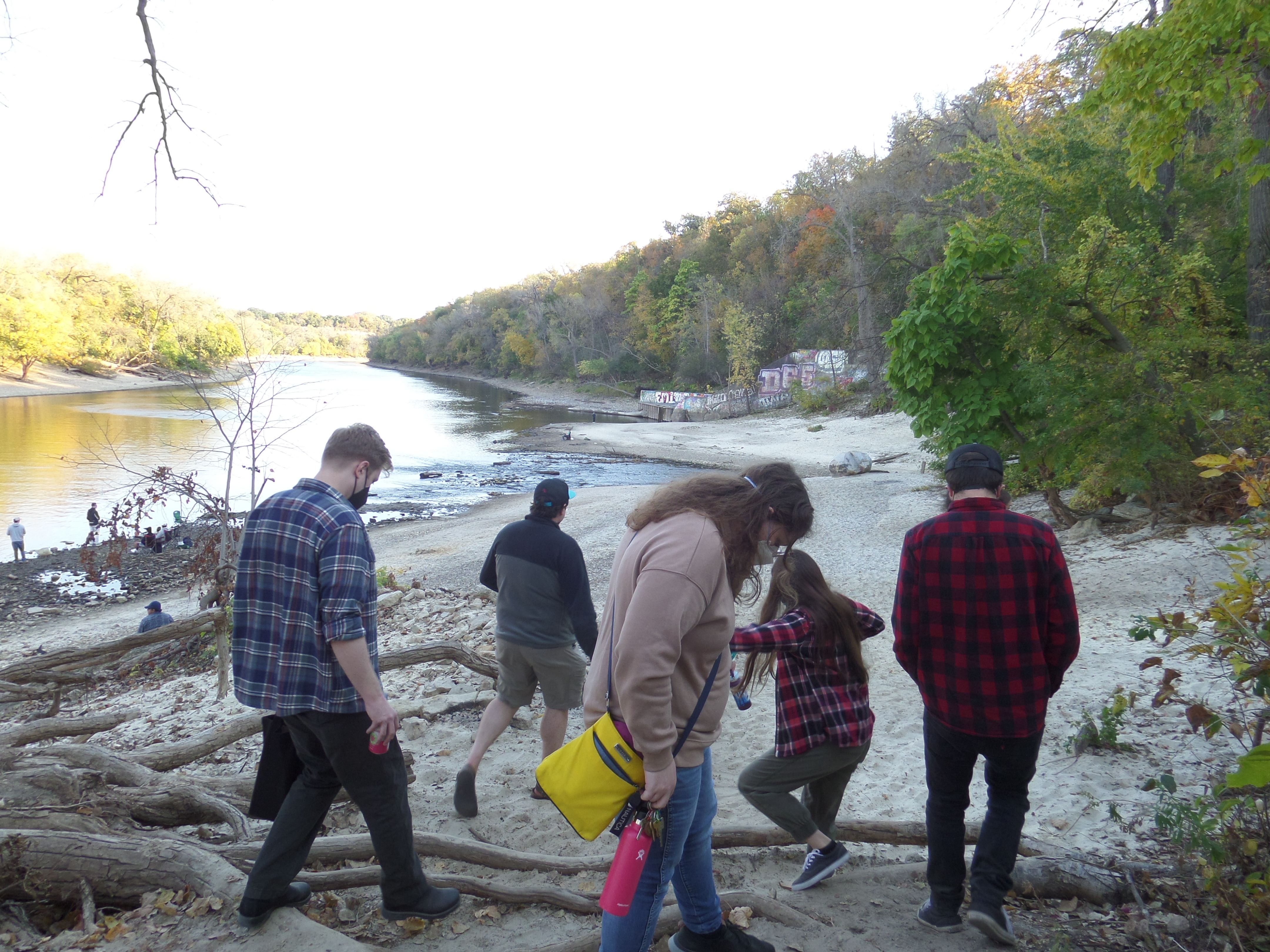 Everyone walking down to the beach. Their footing looks uneven.